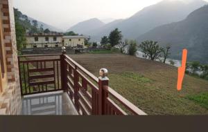 a balcony of a house with a view of a mountain at Vijay Residency in Barkot