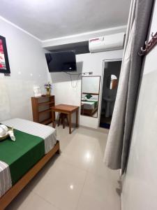 a bedroom with a bed and a desk and a mirror at Hospedaje Humazapa in Tarapoto