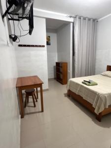 a bedroom with a bed and a desk and a table at Hospedaje Humazapa in Tarapoto