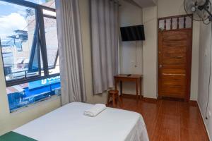 a bedroom with a bed and a window and a television at Hospedaje Humazapa in Tarapoto