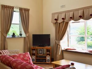 a living room with a couch and a tv at Cornucopia in Portree