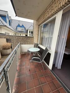 a patio with a table and chairs on a balcony at Hotel Stadt Lübeck in Timmendorfer Strand