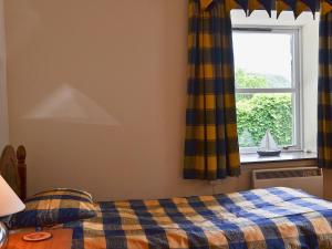 a bedroom with a bed and a window at Cornucopia in Portree +1 photo