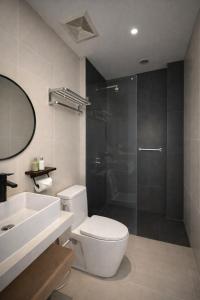 a bathroom with a toilet and a shower and a sink at Infinity Bay Suites in Puerto Galera