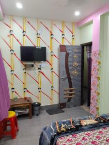 a room with a wall with a tv and a bed at Haramani Guest House in Konārka