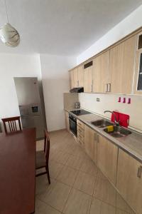 a kitchen with wooden cabinets and a red sink at Aldi APARTMENTS in Lezhë +2 photos