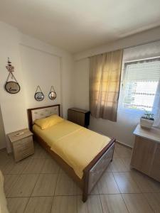 a bedroom with a large bed and a window at Aldi APARTMENTS in Lezhë