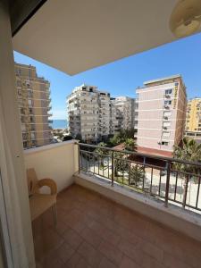 a balcony with a chair and a view of buildings at Aldi APARTMENTS in Lezhë