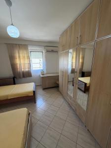 a room with two beds and wooden cabinets at Aldi APARTMENTS in Lezhë