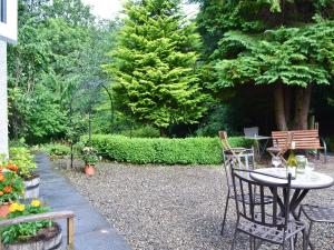a patio with a table and chairs in a garden at Tigh Nan Allt in Dull