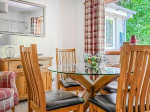 a dining room with a glass table and chairs at Tigh Nan Allt in Dull