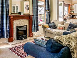 a living room with a couch and a fireplace at Tigh Nan Allt in Dull