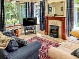 a living room with a couch and a fireplace at Tigh Nan Allt in Dull +6 photos