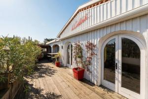 a building with a patio with plants on it at Hôtel Le Caillebotis in Cap-Ferret