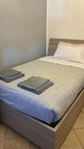 a bed with two towels on top of it at Fabio Filzi 32 sub 7 in Lainate