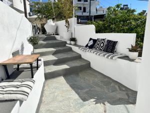a stairway with a bench and a wooden table at Babatseratsi skyrian studio 2 in Skiros