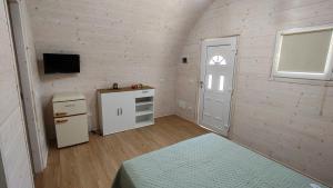 a small room with a refrigerator and a television at Camping Luni in Marina di Massa