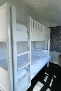 two white bunk beds in a room at Motel l'eau vive in Raon-lʼÉtape