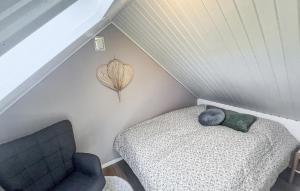 a attic room with a bed and a chair at 3 Bedroom Cozy Home In Haderslev in Haderslev +11 photos