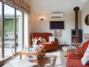 a living room with a couch and a table at Shelduck Cottage in Holmfirth