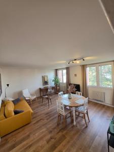 a living room with a yellow couch and a table at Chez Marie et Ludovic in Ronchin
