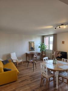 a living room with a yellow couch and a table at Chez Marie et Ludovic in Ronchin