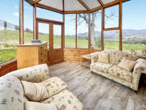 a living room with two couches and a large window at Whiteburn in Pitlochry