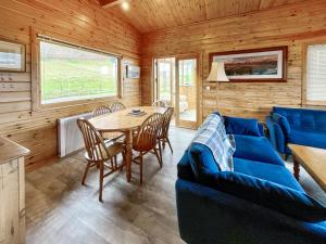 a living room with a blue couch and a table at Whiteburn in Pitlochry