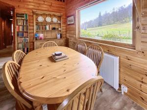 a wooden table and chairs in a room with a window at Whiteburn in Pitlochry