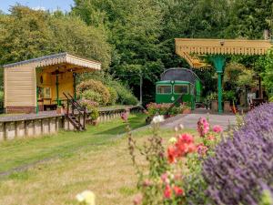 a small train station with a green train at Sprat & Winkle in Horsebridge