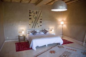 a bedroom with a bed and a painting on the wall at RIAD AMAN SKOURA in Skoura +50 photos