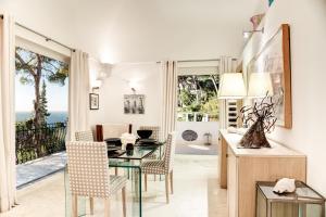 a dining room with a table and chairs and a view of the ocean at GOCCE VILLAS - Villa Bouganvillea Superb Capri Villa with Views in Capri