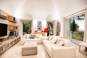 a living room with white furniture and a large window at GOCCE VILLAS - Villa Bouganvillea Superb Capri Villa with Views in Capri