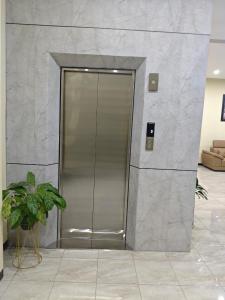 a elevator in a building with a plant in front of it at green hotel 2 ciamis in Ciamis