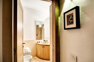 a bathroom with a sink and a toilet and a mirror at GOCCE VILLAS - Villa Bouganvillea Superb Capri Villa with Views in Capri