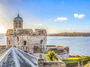 an old lighthouse on the shore of a body of water at The Sail Room in Saint Mawes +6 photos