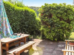 a patio with a wooden table and a umbrella at Brynhafod in Llanfihangel-geneuʼr-glyn
