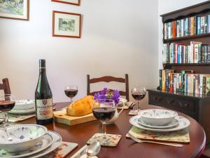 a dining room table with a bottle of wine and glasses at Brynhafod in Llanfihangel-geneuʼr-glyn +10 photos
