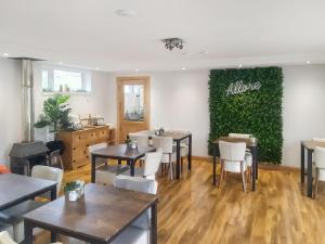a restaurant with tables and chairs and a green wall at Eskside Lodge in Brechin