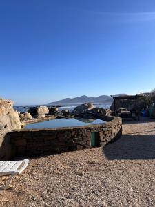 a bench and a pool of water on a beach at Departamentos Océano in Maitencillo
