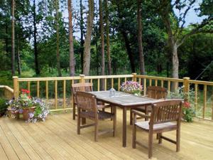 a wooden deck with a wooden table and chairs at The Old Packhouse in Steyning