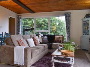 a living room with a couch and a table at Timbers in Woolfardisworthy