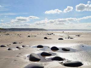 a beach with some rocks in the sand at Timbers in Woolfardisworthy +9 photos