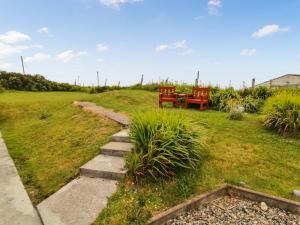 a garden with a table and chairs in the grass at Maari in Trumisgarry
