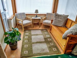 a room with two chairs and a table and a rug at Maari in Trumisgarry