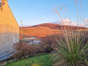 a view of a hill with a church and a field at Maari in Trumisgarry