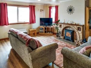 a living room with two couches and a fireplace at Maari in Trumisgarry