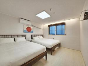 a bedroom with two beds and a window at Check in Seoul in Hongdae 2 in Seoul