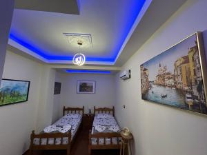 two beds in a room with a blue ceiling at Vila Spaho in Korçë +28 photos