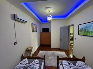 a room with two beds and a blue ceiling at Vila Spaho in Korçë